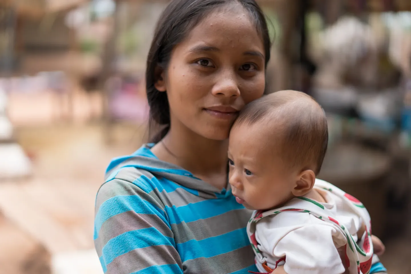 A mother in Lao PDR holds her 5-month-old son, who has just received a polio vaccine.