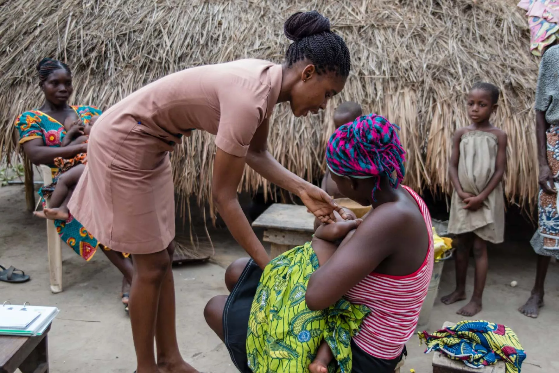 A community healthworker assisting a woman who is breastfeeding