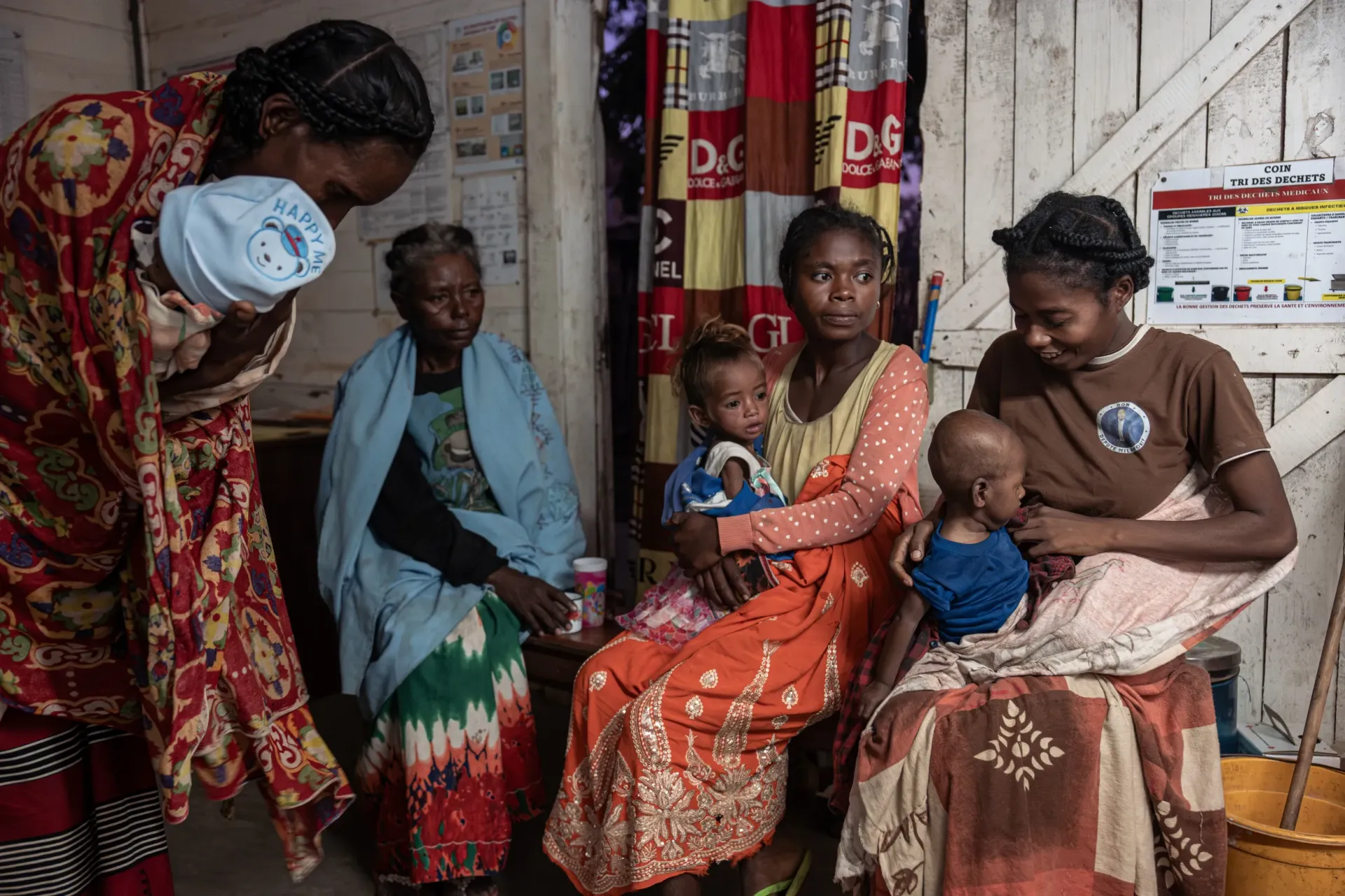 At the Intensive Nutritional Recovery and Education Center (CRENI) of Ambovombe, Androy Region, Madagascar, three women hold their children, waiting to receive their scheduled dose of F-75 therapeutic milk.